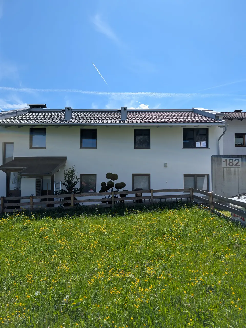 Frisch sanierte weiße Mehrparteienhaus-Fassade in Münster, Tirol — nach Algenentfernung und zweifachem Anstrich mit Brillux SECOLUX Protect