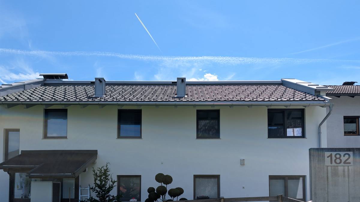 Frisch sanierte weiße Mehrparteienhaus-Fassade in Münster, Tirol — nach Algenentfernung und zweifachem Anstrich mit Brillux SECOLUX Protect