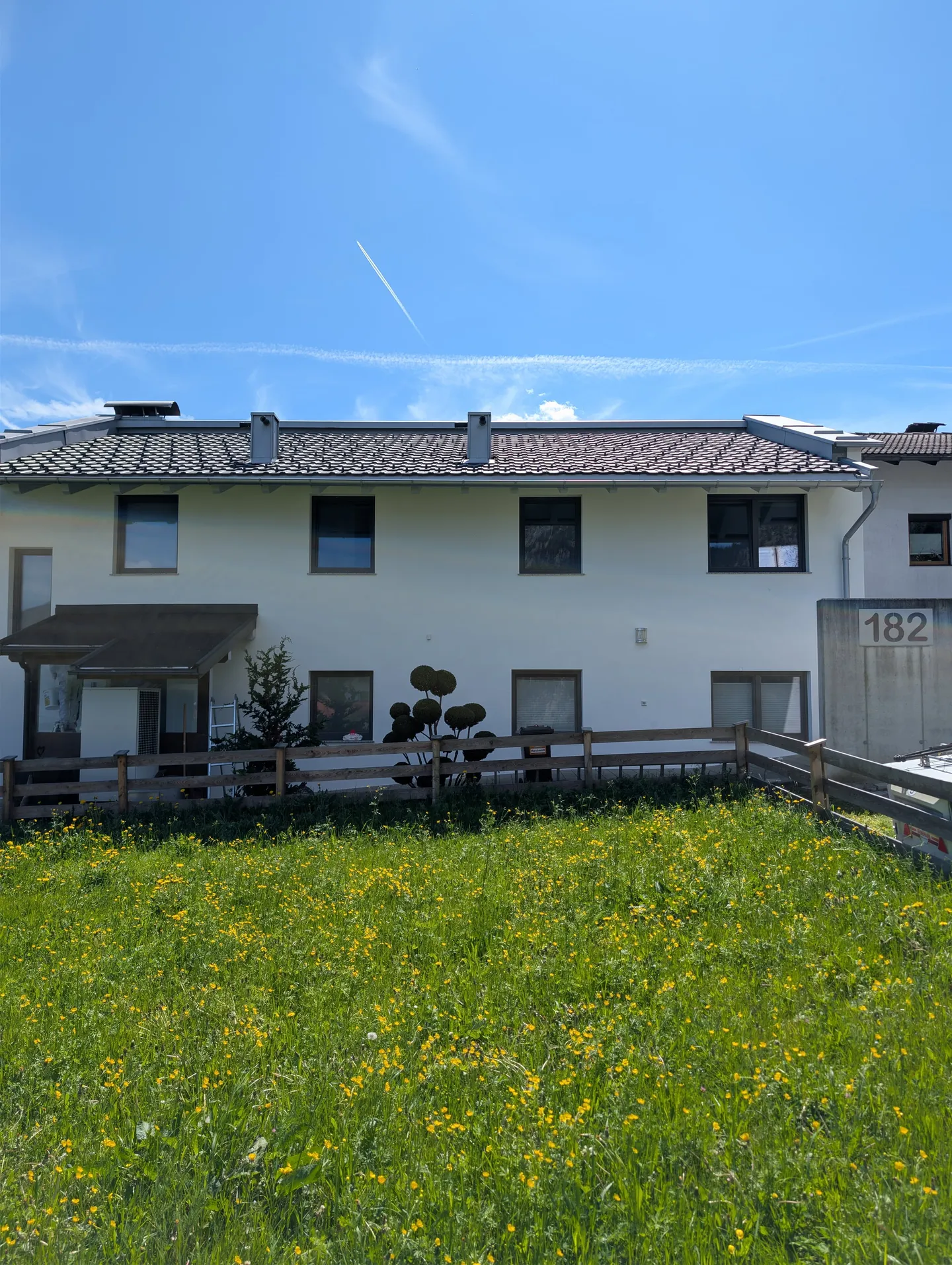 Frisch sanierte weiße Mehrparteienhaus-Fassade in Münster, Tirol — nach Algenentfernung und zweifachem Anstrich mit Brillux SECOLUX Protect