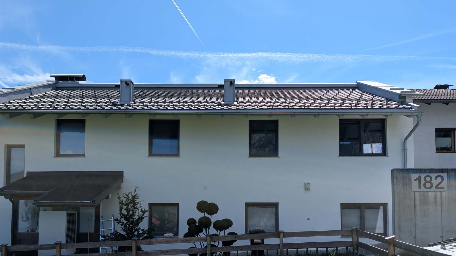 Frisch sanierte weiße Mehrparteienhaus-Fassade in Münster, Tirol — nach Algenentfernung und zweifachem Anstrich mit Brillux SECOLUX Protect