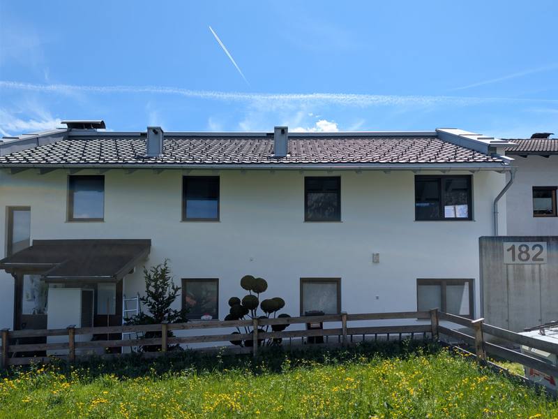 Frisch sanierte weiße Mehrparteienhaus-Fassade in Münster, Tirol — nach Algenentfernung und zweifachem Anstrich mit Brillux SECOLUX Protect