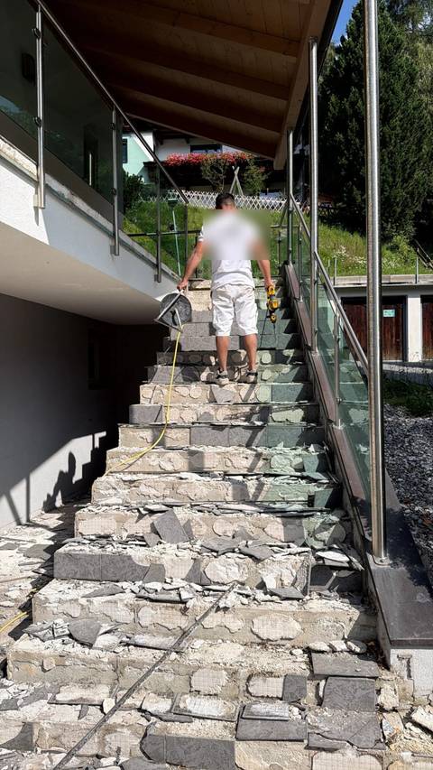 Mikrozement wird von Hand mit der Kelle auf eine Stiege aufgezogen.